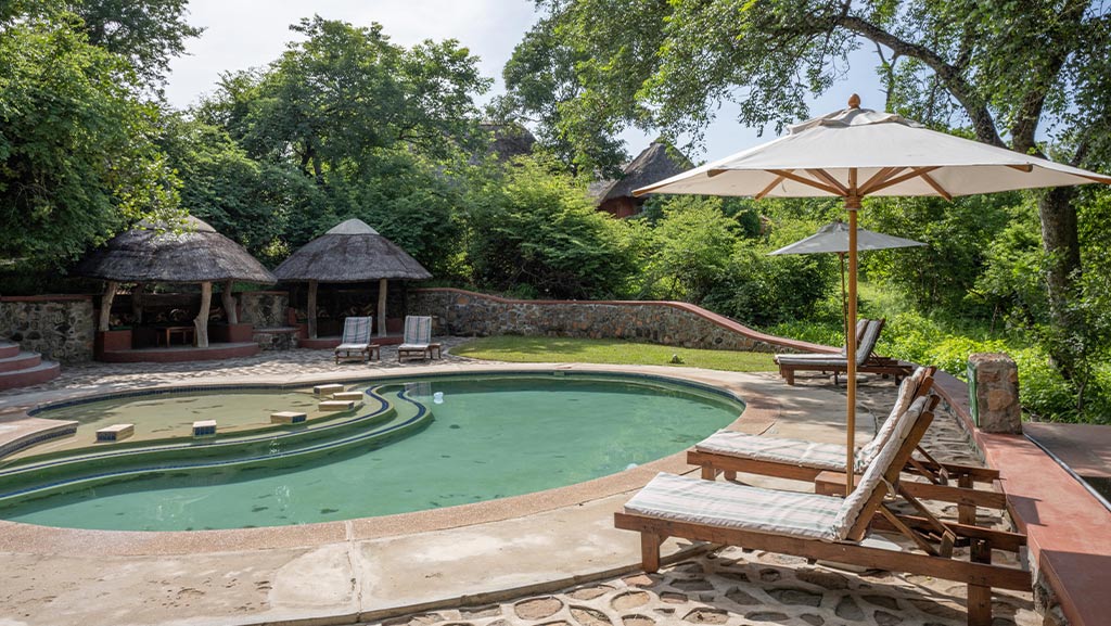 The Mwembezi Restaurant with a pool and lounge chairs to sit by the pool